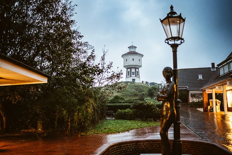 Wasserturm und nasse Straße am frühen Morgen