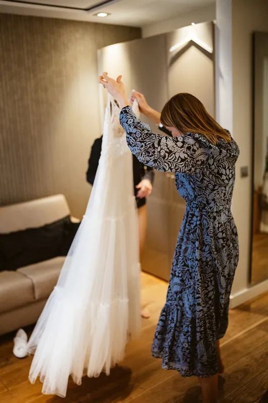 Das Brautkleid wird vom Bügel genommen