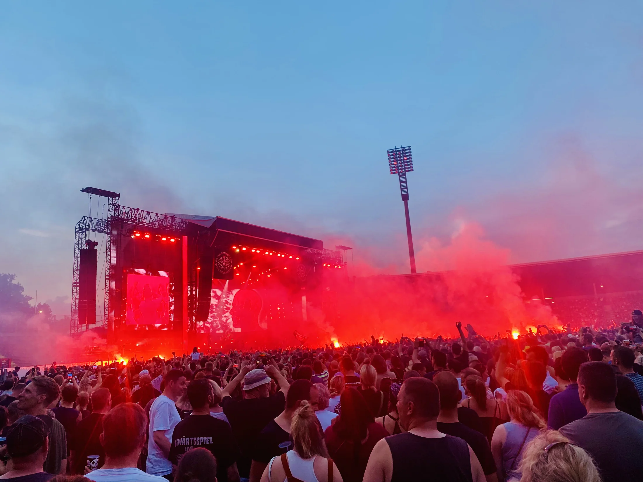 Festivalbühne in rotem Licht, davor das Publikum