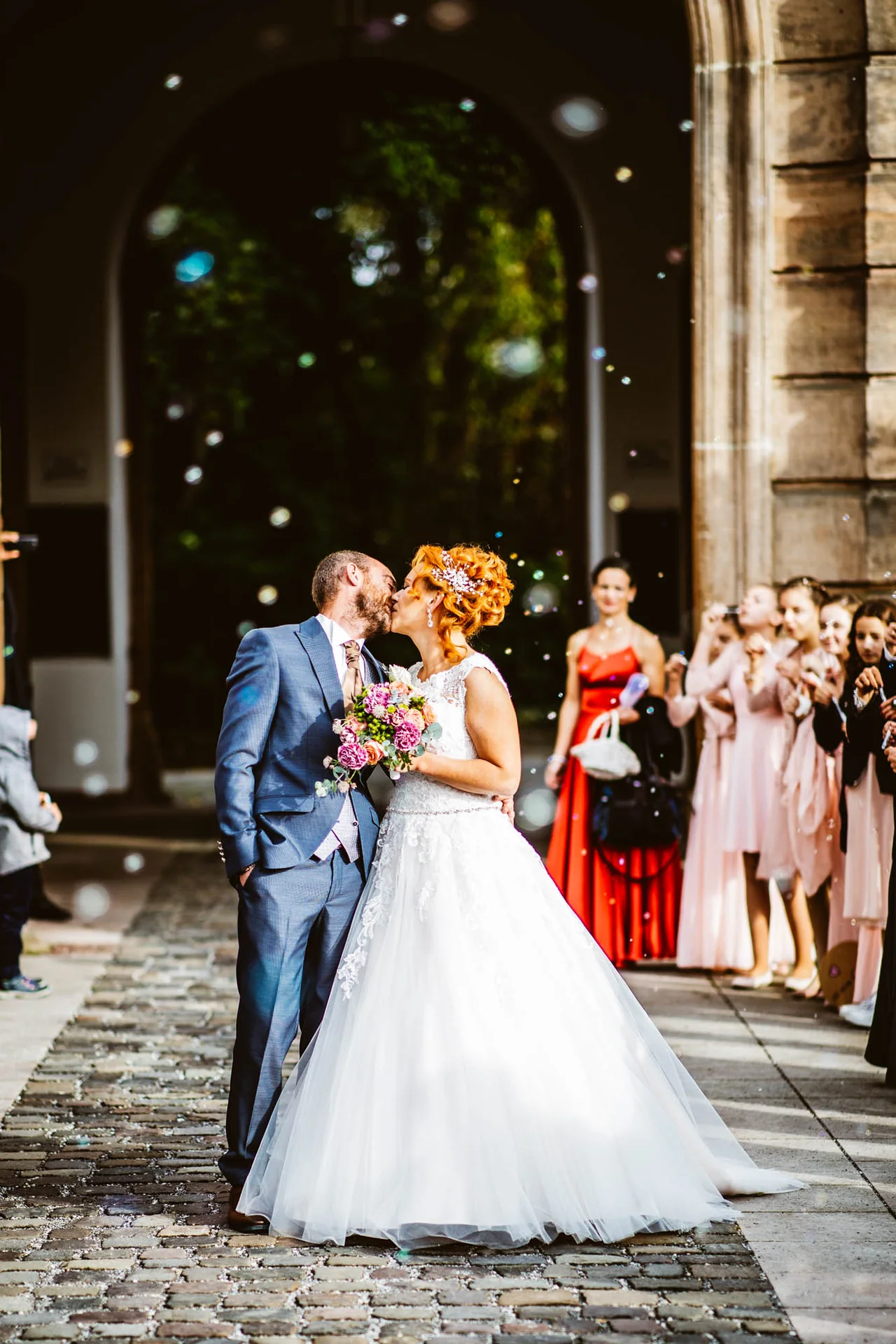 Hochzeitspaar jubelt vor der Kirche