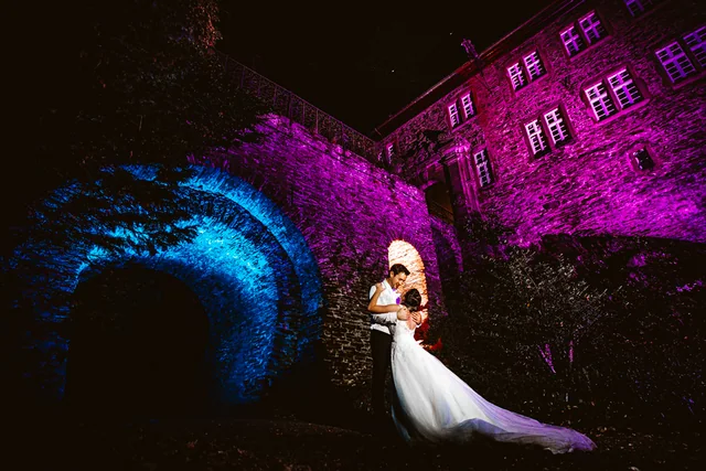 Hochzeitspaar vor einer abendlich beleuchteten Location