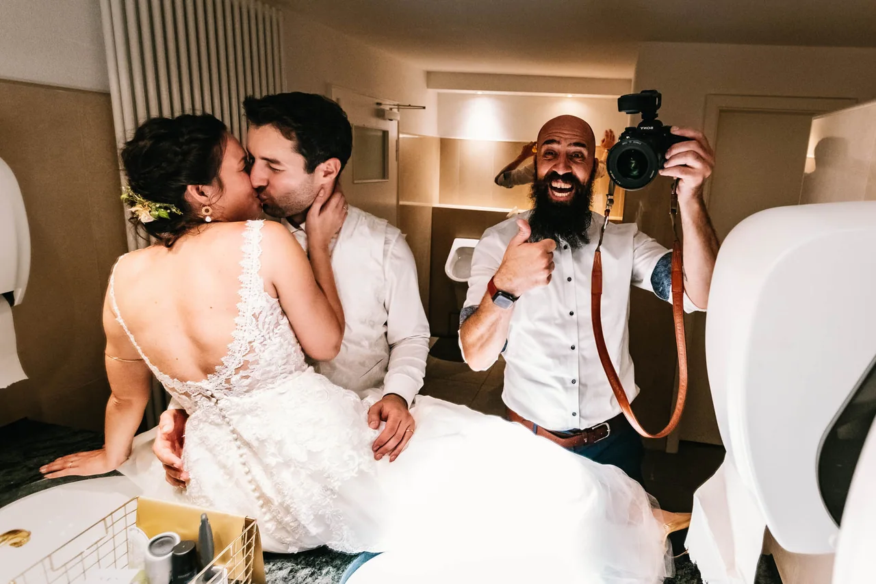 Marc lacht mit einem Hochzeitspaar während er die Kamera hält
