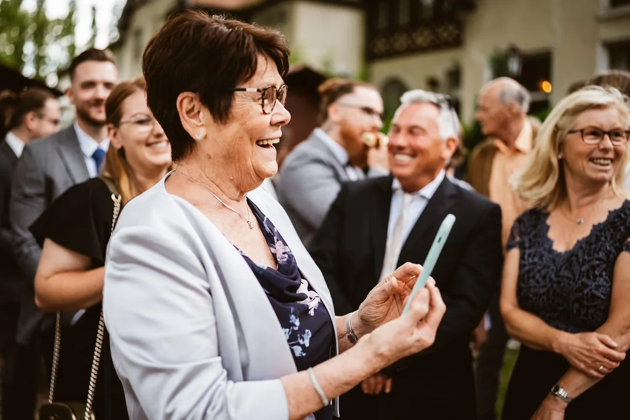 Die Oma freut sich über ihr Handyfoto vom Brautpaar