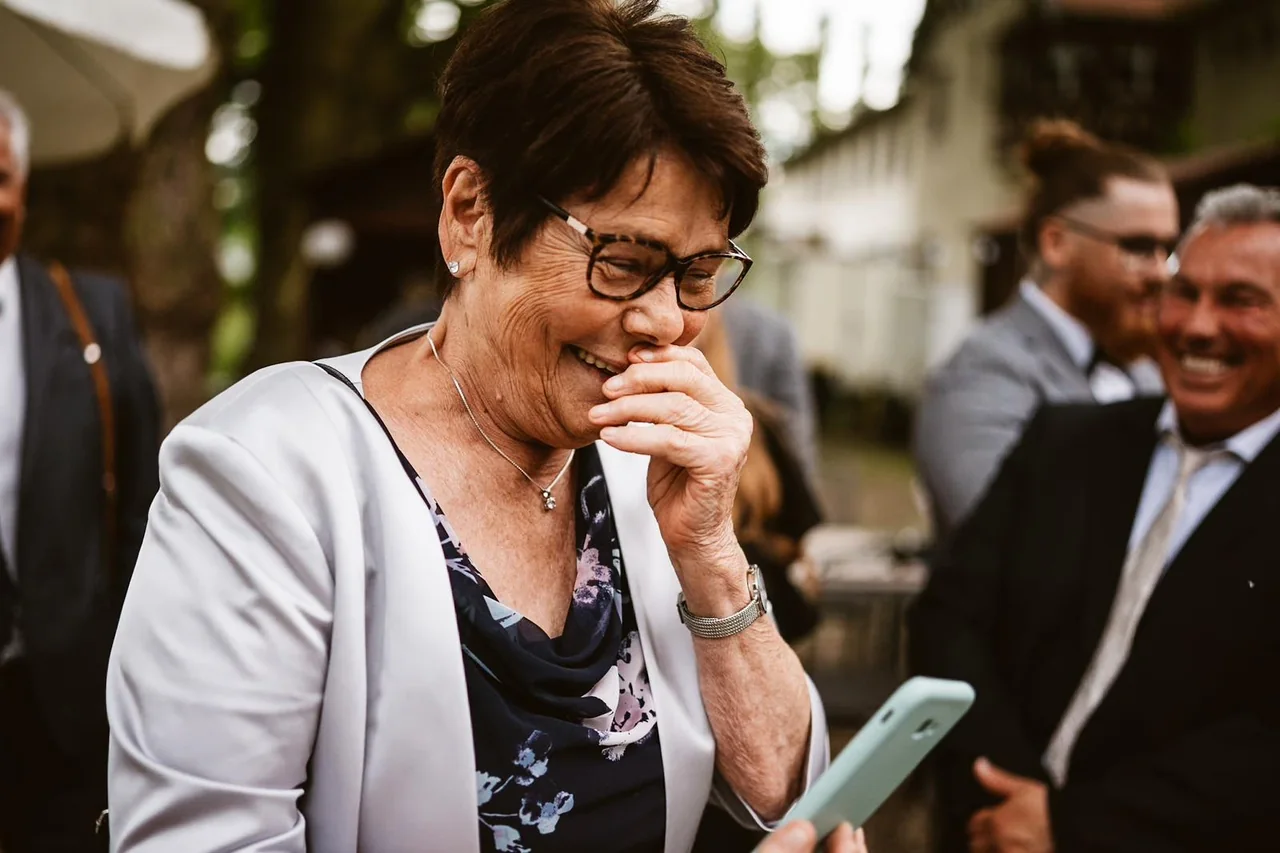 Die Oma lächelt gerührt beim Blick auf ihr Foto