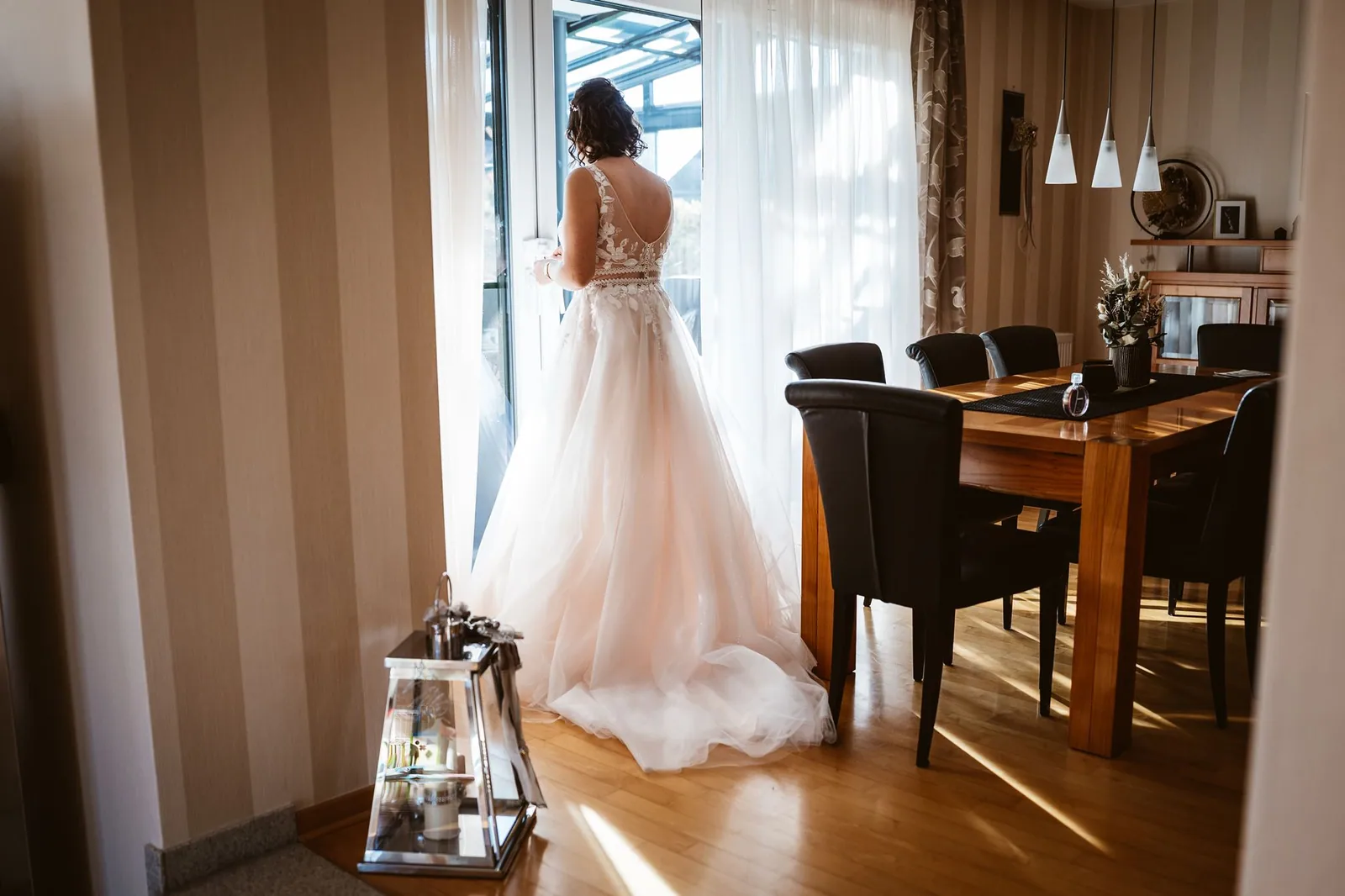 Ricarda steht im Brautkleid am Fenster im Elternhaus