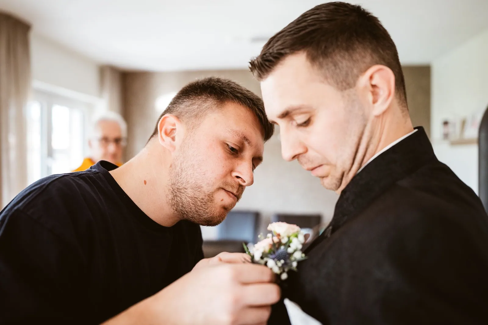 Alex und ein weiterer Mann befestigen den Blumenanstecker