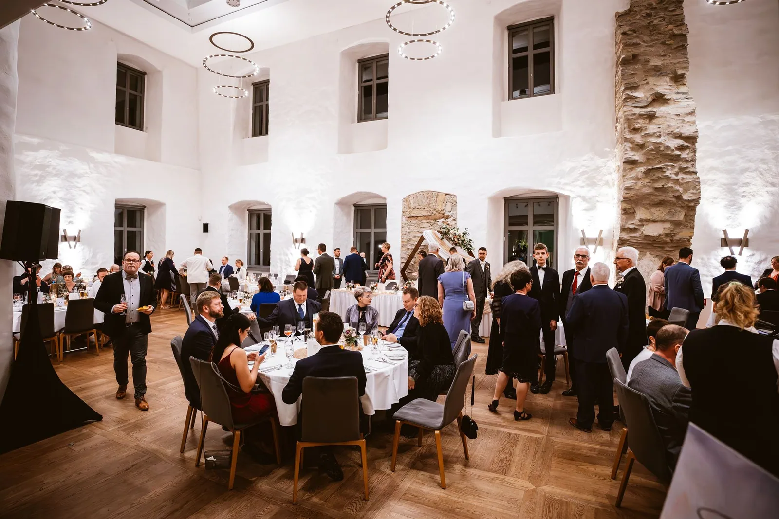 Die Gäste sitzen im Festsaal an den Hochzeitstischen
