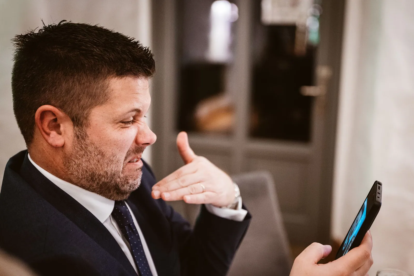 Ein Gast schaut lächelnd auf sein Handy