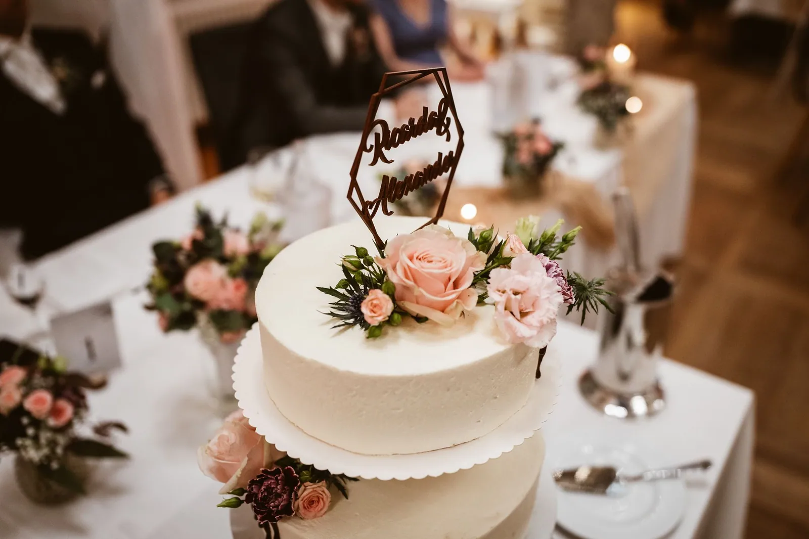 Die Hochzeitstorte mit Blumen und den Namen des Paars